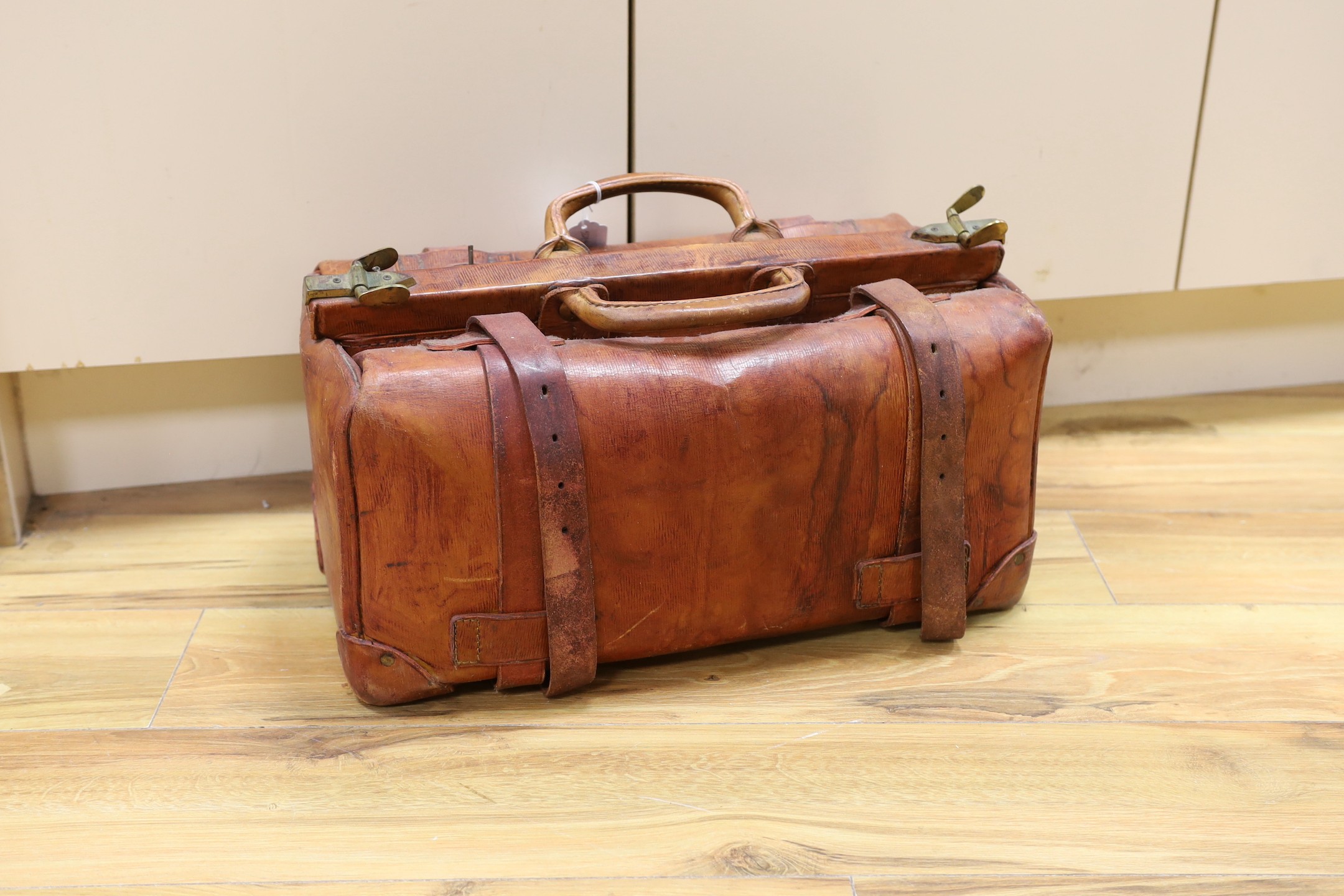 A brown leather Gladstone bag